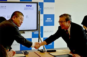 今年6月の東京工業大学・武蔵野美術大の協定締結式で握手する
三島良直・東工大学長(右)と甲田洋二・武蔵野美大学長