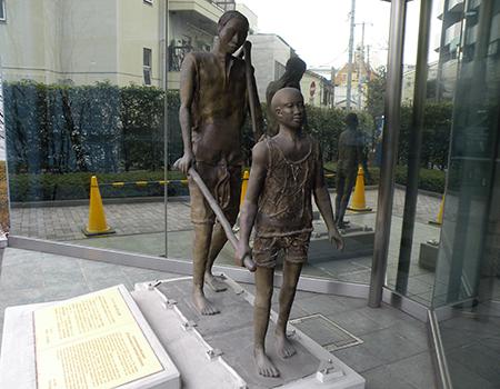 北里研究所(東京・白金)の玄関脇にあるオンコセルカ撲滅運動を記念した銅像