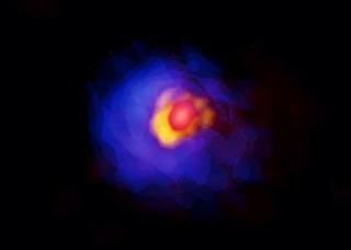 アルマ望遠鏡が撮影した巨大原始星「G353.273+0.641」。原始星周囲のコンパクトな構造を赤、円盤を黄、その外側に広がるガスを青に着色して疑似カラー合成してある(Credit: ALMA (ESO/NAOJ/NRAO), Motogi et al)