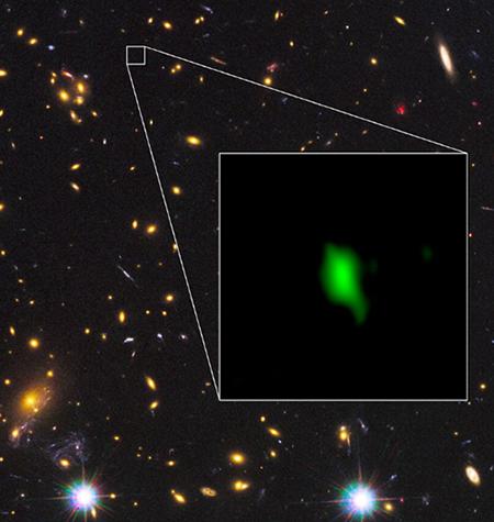 画像1 ハッブル宇宙望遠鏡が赤外線で撮影した銀河団MACS J1149.5+2223の画像の一角に、アルマ望遠鏡が電波で観測した銀河MACS1149-JD1を合成した画像。実際にはMACS1149-JD1は銀河団よりもずっと遠い場所にあるが、地球から見ると偶然重なって見える。画像では、アルマ望遠鏡が観測した酸素の分布を緑色で表現している（説明文・大阪産業大学、国立天文台などの研究チーム）〈クレジット・ALMA(ESO/NAOJ/NRAO), NASA/ESA Hubble Space Telescope, W. Zheng (JHU), M. Postman (STScI), the CLASH Team, Hashimoto et al〉