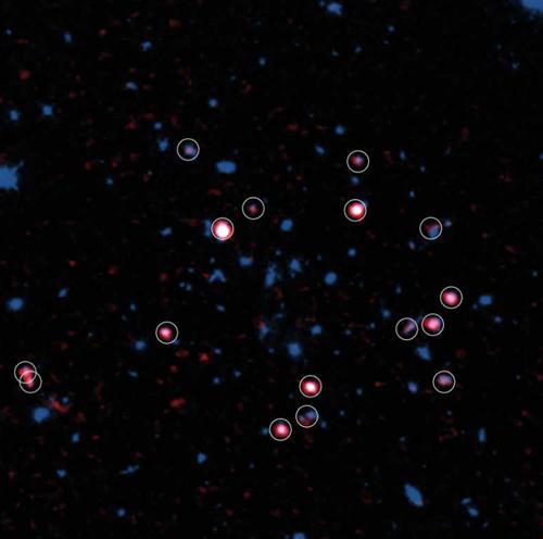 画像1 アルマ望遠鏡とハッブル宇宙望遠鏡で観測した、94億光年かなたの銀河団XMMXCS J2215.9?1738。アルマ望遠鏡が見つけたガスに富む銀河を赤色で表示し、さらに白丸で囲んでいる。これらの銀河が、銀河団の中心部(画像中央部)には存在しないことが分かる(Credit: ALMA (ESO/NAOJ/NRAO), Hayashi et al., the NASA/ESA Hubble Space Telescope/国立天文台提供)