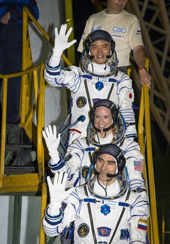 写真2 ソユーズ宇宙船に乗り込む大西卓哉さん(宇宙服を来た3人の一番上)ら3人の搭乗員(提供NASA/Bill Ingalls)