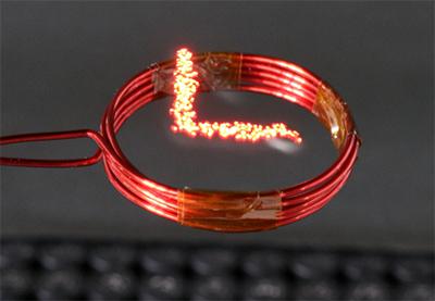 写真3 点灯、消灯を繰り返しながらルシオラを動かすと、20秒間でこの範囲を光で埋めることができる。下のコイルで、ルシオラに電気のエネルギーを送る。コイルの直径は約3センチメートル。(研究グループ提供)