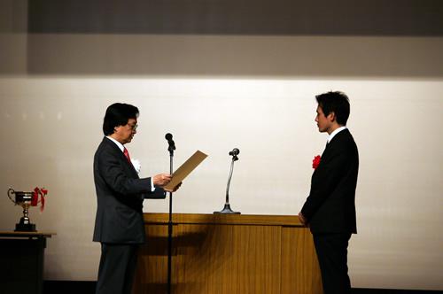 表彰式より。内閣総理大臣賞を授与する藤井文部科学副大臣(左)と今井監督(右)
