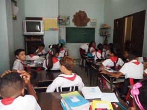 写真1、2．キューバの小学校の様子(左)、日本の紹介に目を輝かせる子どもたち(右)