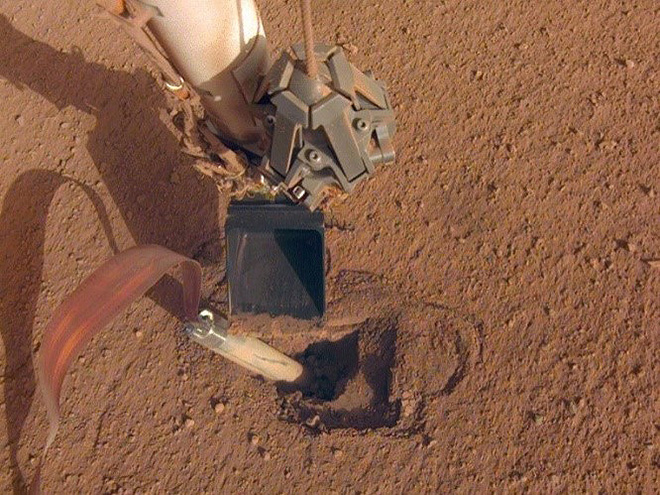 土壌に打ち込めない熱流量計（下）と、支援を試みるロボットアーム（NASA提供）