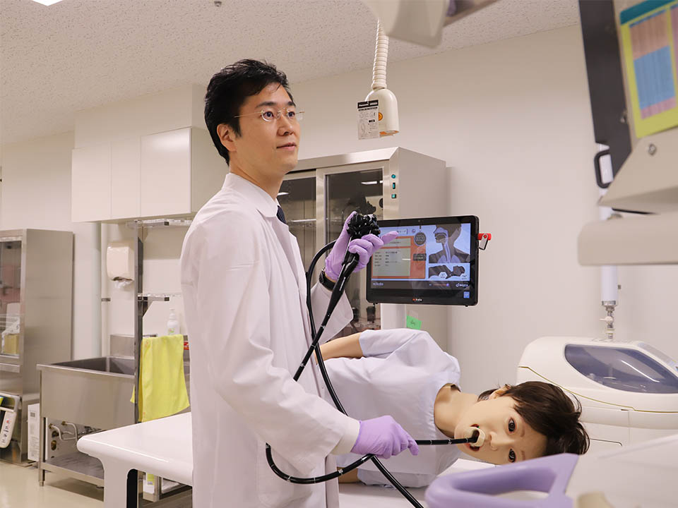 
鳥取大学医学部附属病院が共同開発した医療用シミュレーターロボットに内視鏡を挿入する植木賢さん(米子