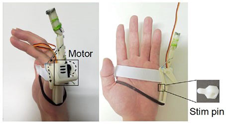 開発した人工指「sixth finger」を装着した状態。動かすとピン（Stim pin）が手に当たることで、動いている感覚が伝わる（電気通信大学提供）
