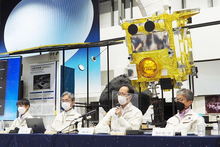 はやぶさ2の模型を前に会見する津田雄一プロジェクトマネージャ（左から3人目）ら、チームメンバー＝6月29日、相模原市中央区のJAXA宇宙科学研究所