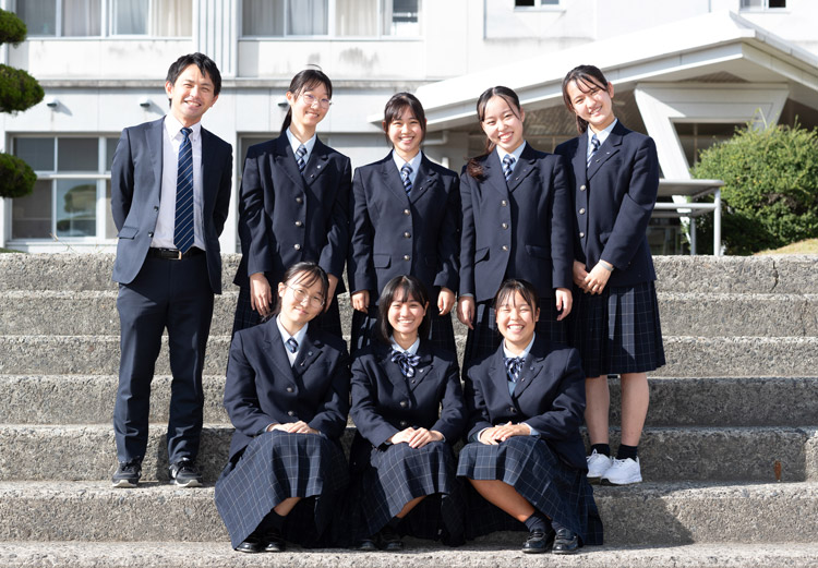 校舎の前で記念撮影。生活科理科班の7人と左端は教諭の大野さん