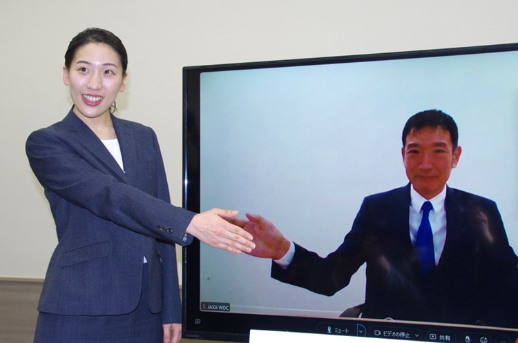 会見で、報道陣の求めに応じて握手のポーズを取る米田さん（左）と諏訪さん＝28日、東京都千代田区