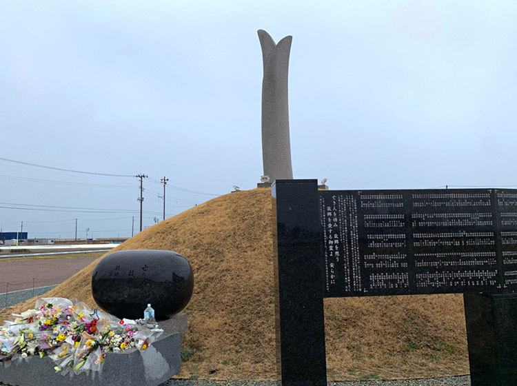 震災メモリアル公園の祈りの広場に建てられた東日本大震災慰霊碑。空に伸びる「芽生えの塔」は津波高と同じ8.4メートル。閖上地区で亡くなった人の全員の名前も刻まれている（3月13日午後撮影）
