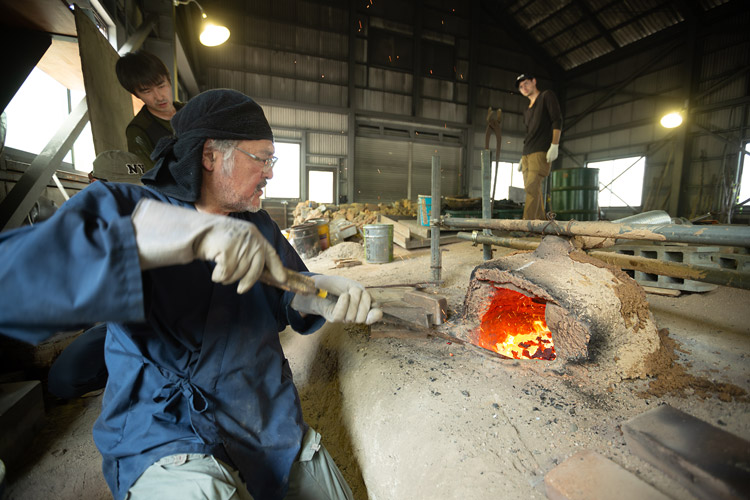 岡山県新見（にいみ）市のたたら操業施設で村上さん（左手前）と研究室のメンバー、地元の人々が協力して和鉄作りの復活に取り組んでいる