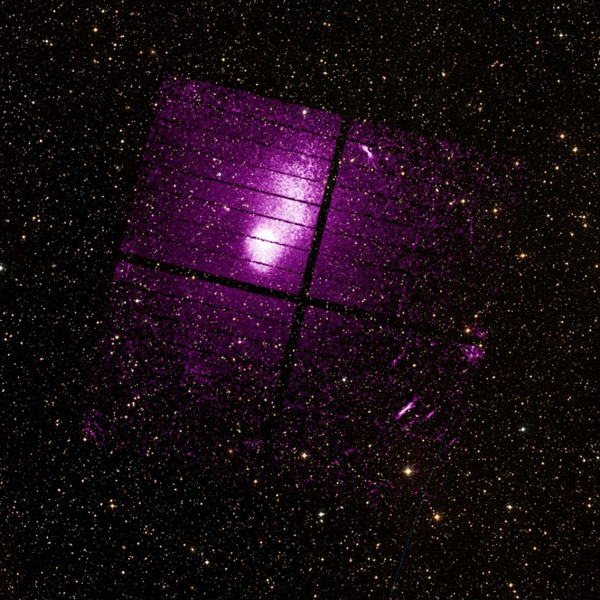 クリズムのCCDカメラが撮影した銀河団「エイベル2319」。2つの銀河団が衝突している。画像はクリズムの画像（紫色で表現）に、可視光の画像を重ねたもの。撮像素子の構造上、黒い直線が入る（JAXA、デジタイズド・スカイ・サーベイ提供）