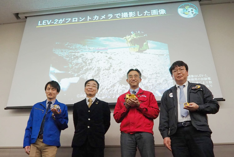 会見後、撮影に応じる國中氏（左から2人目）、坂井氏（3人目）と、小型ロボットの担当者ら＝25日、東京都千代田区