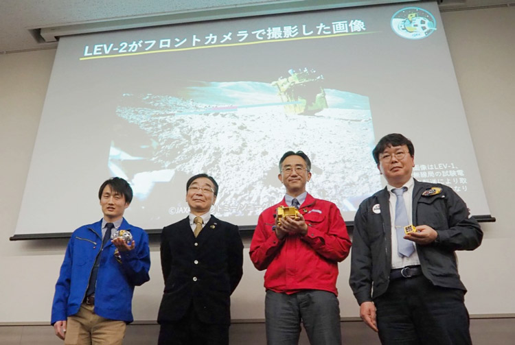 会見後、撮影に応じる國中氏(左から2人目)、坂井氏(3人目)と、小型ロボットの担当者ら=25日、東京都千代田区