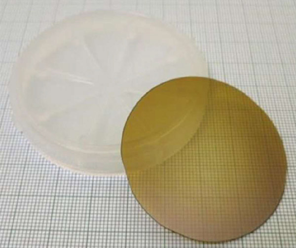 今回の実験で用いた高品質な窒化アルミニウムの単結晶基板。直径約2インチ（50ミリメートル）で、厚さは0.5ミリメートル（旭化成提供）